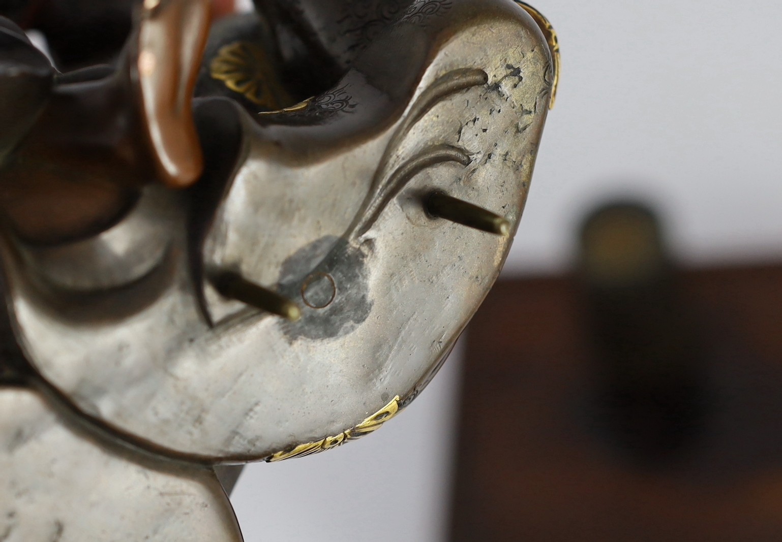 A Japanese bronze model of a sword fittings master craftsman, by Miyao Eisuke, Meiji period, total height 18cm including original gilt lacquered wood stand, small section of bronze lacking